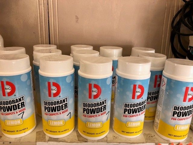 A bunch of bottles of deodorant powder are sitting on a shelf