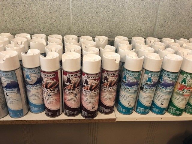 A bunch of spray bottles are lined up on a shelf