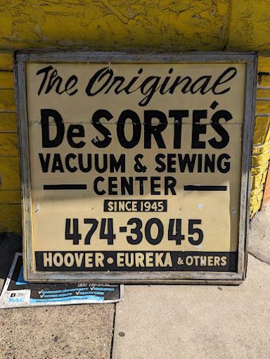 A sign for de sorte 's vacuum and sewing center
