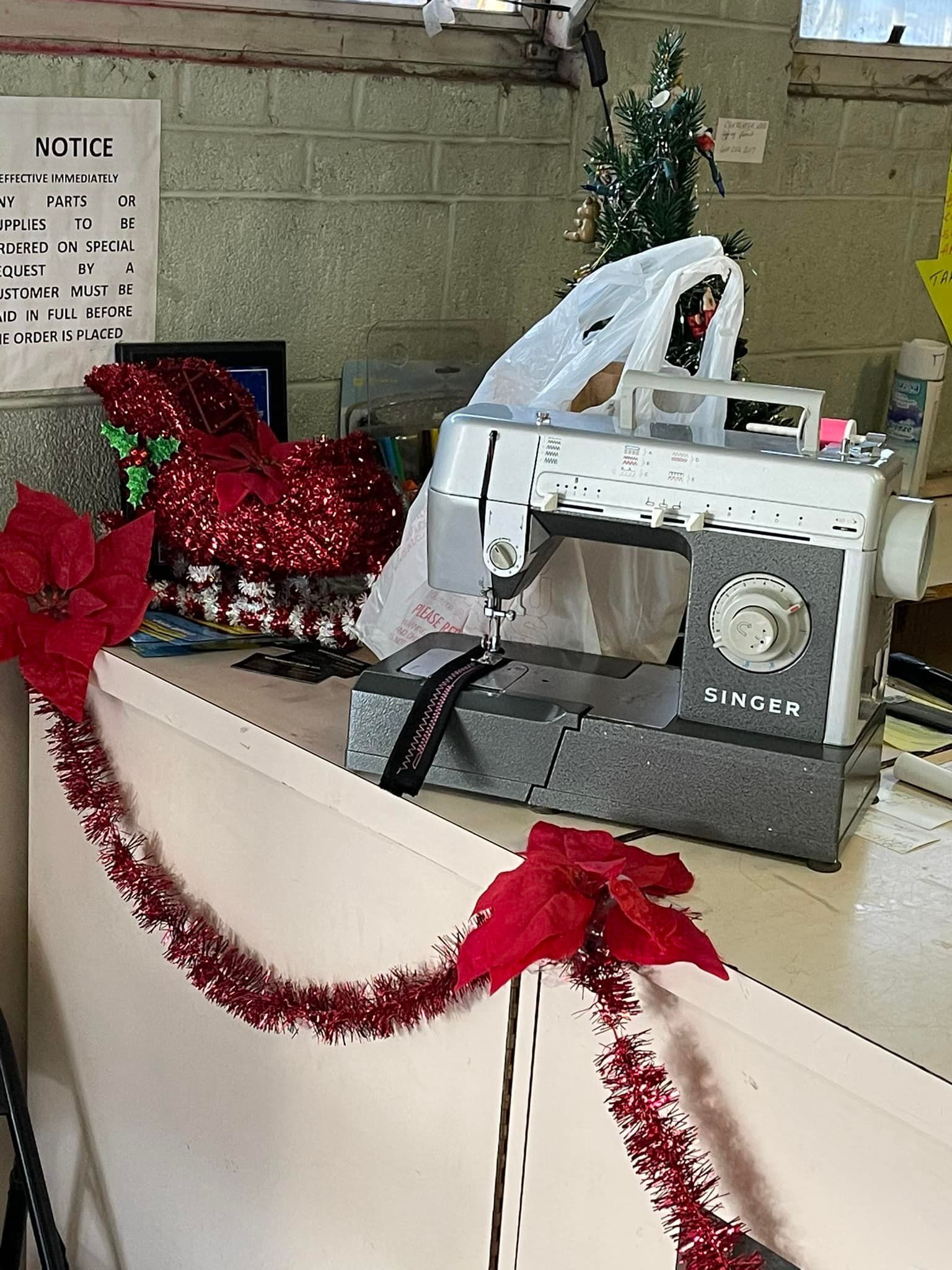 A sewing machine is sitting on a counter decorated for Christmas
