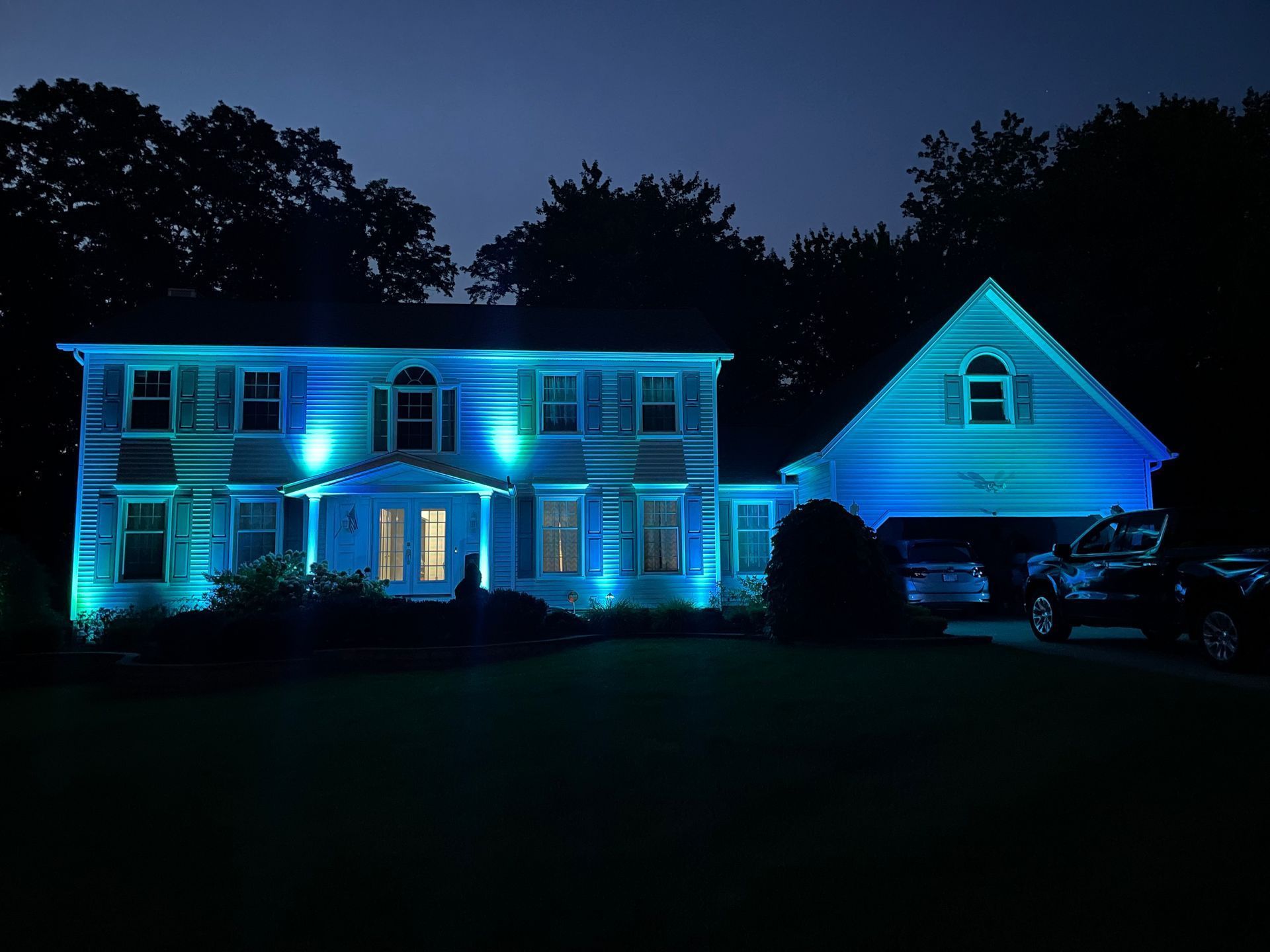 House illuminated with blue lights at night.