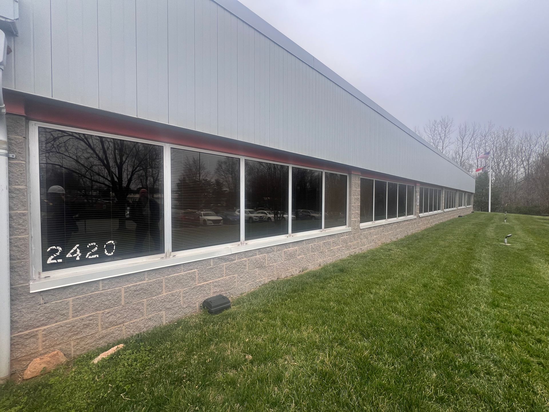 A large building with a lot of windows and a lawn in front of it.