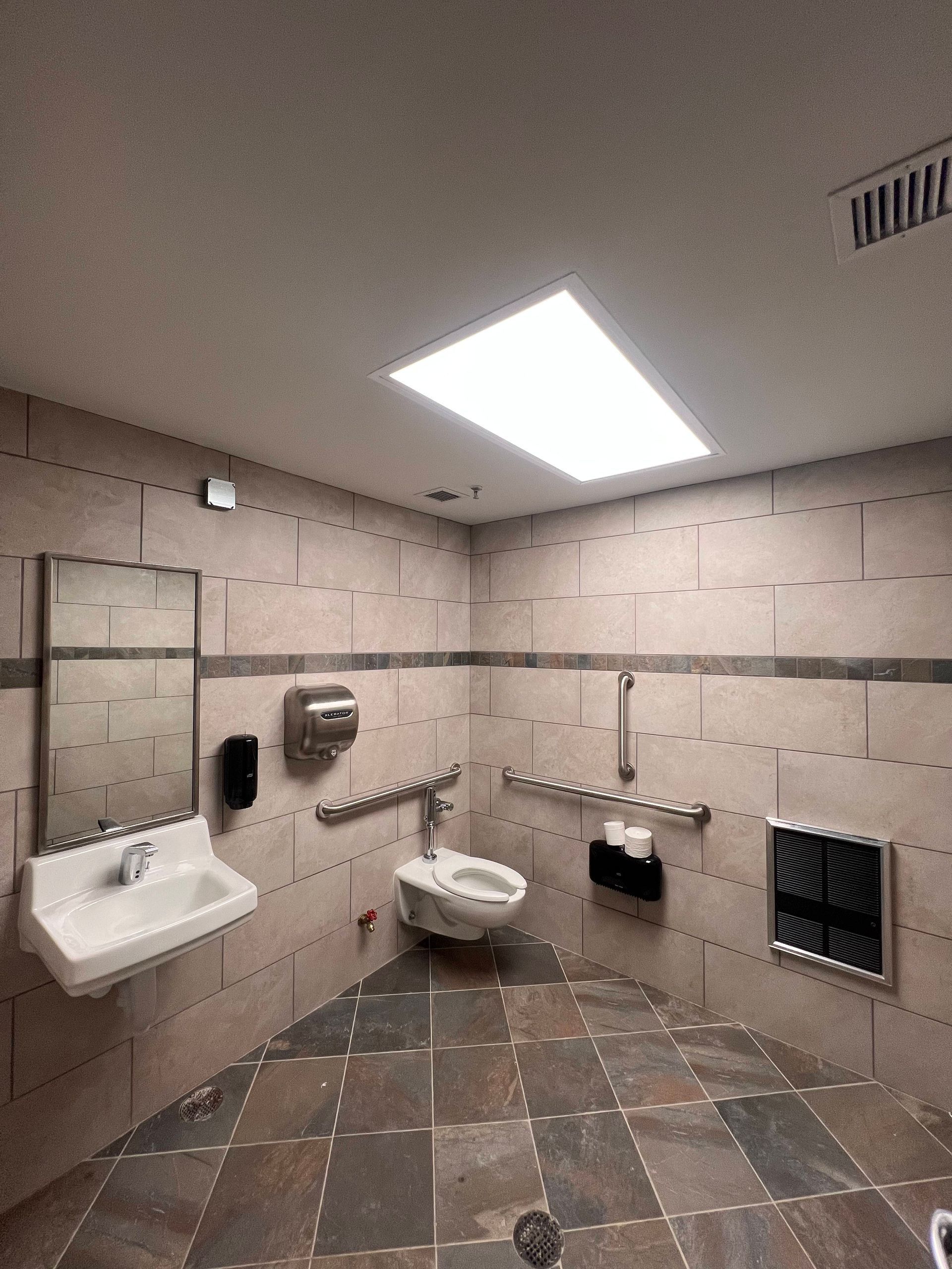 A bathroom with a sink , toilet and mirror
