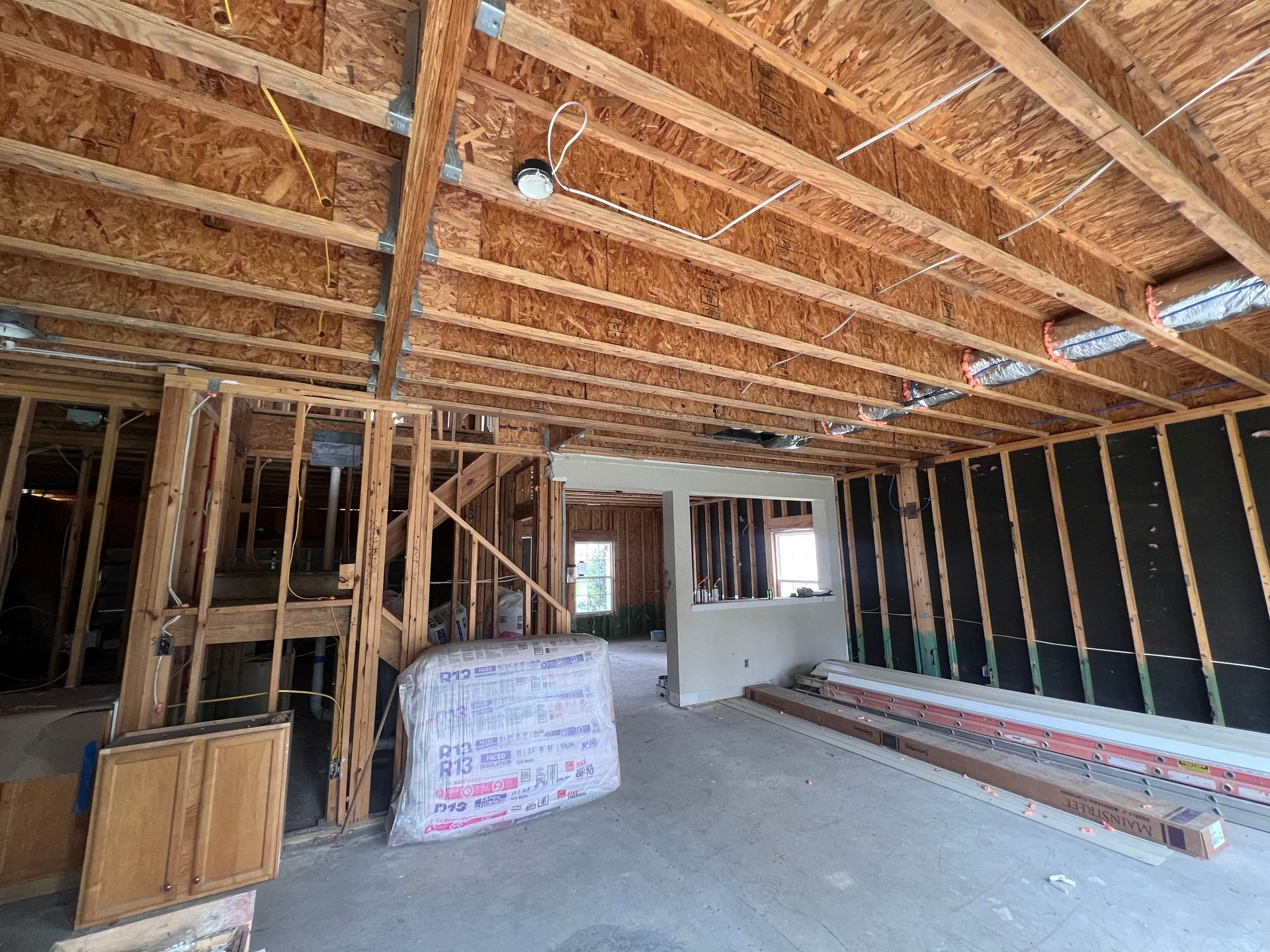The inside of a house under construction with a lot of wooden beams.