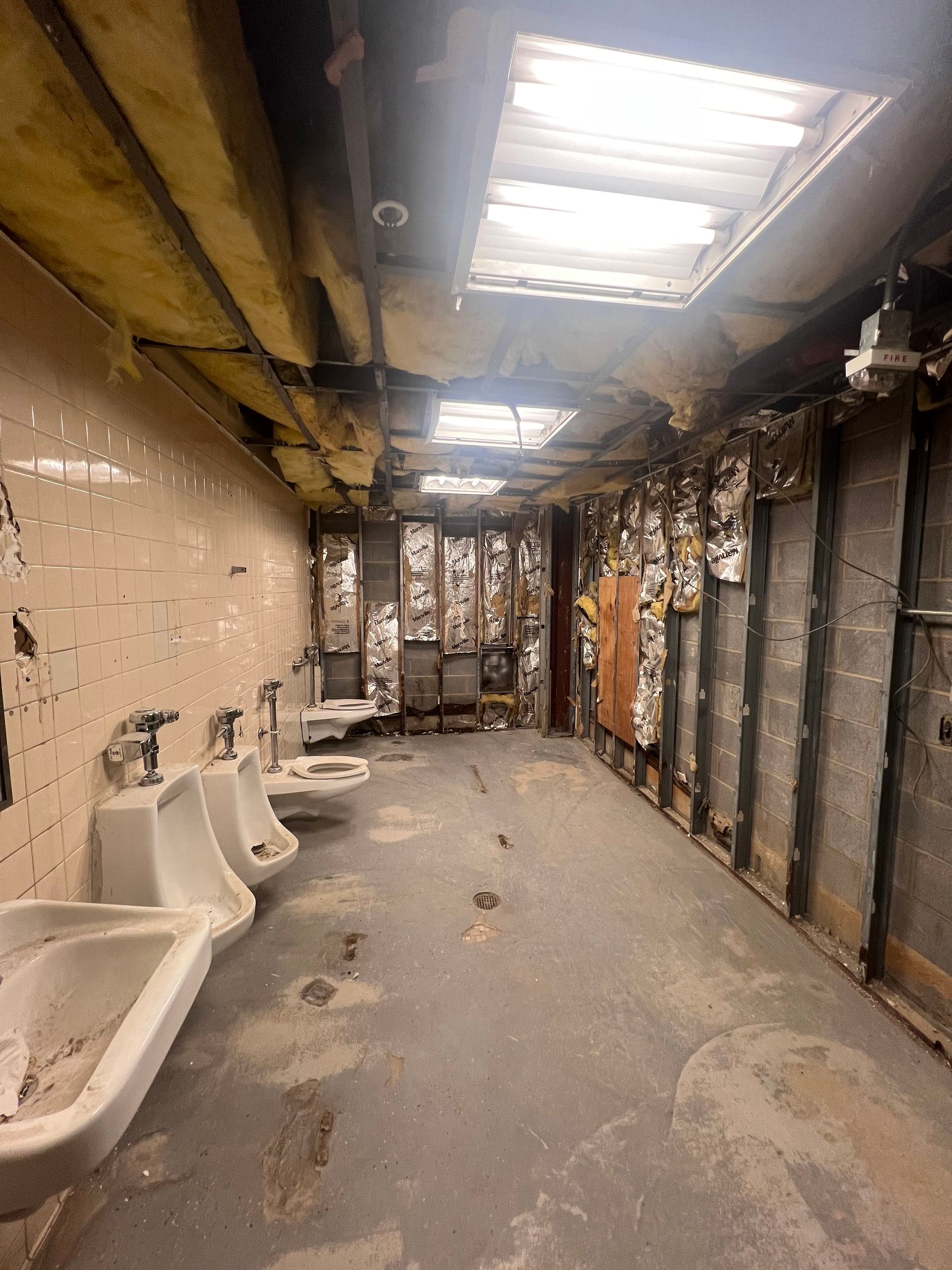 A bathroom with a lot of urinals and sinks in it