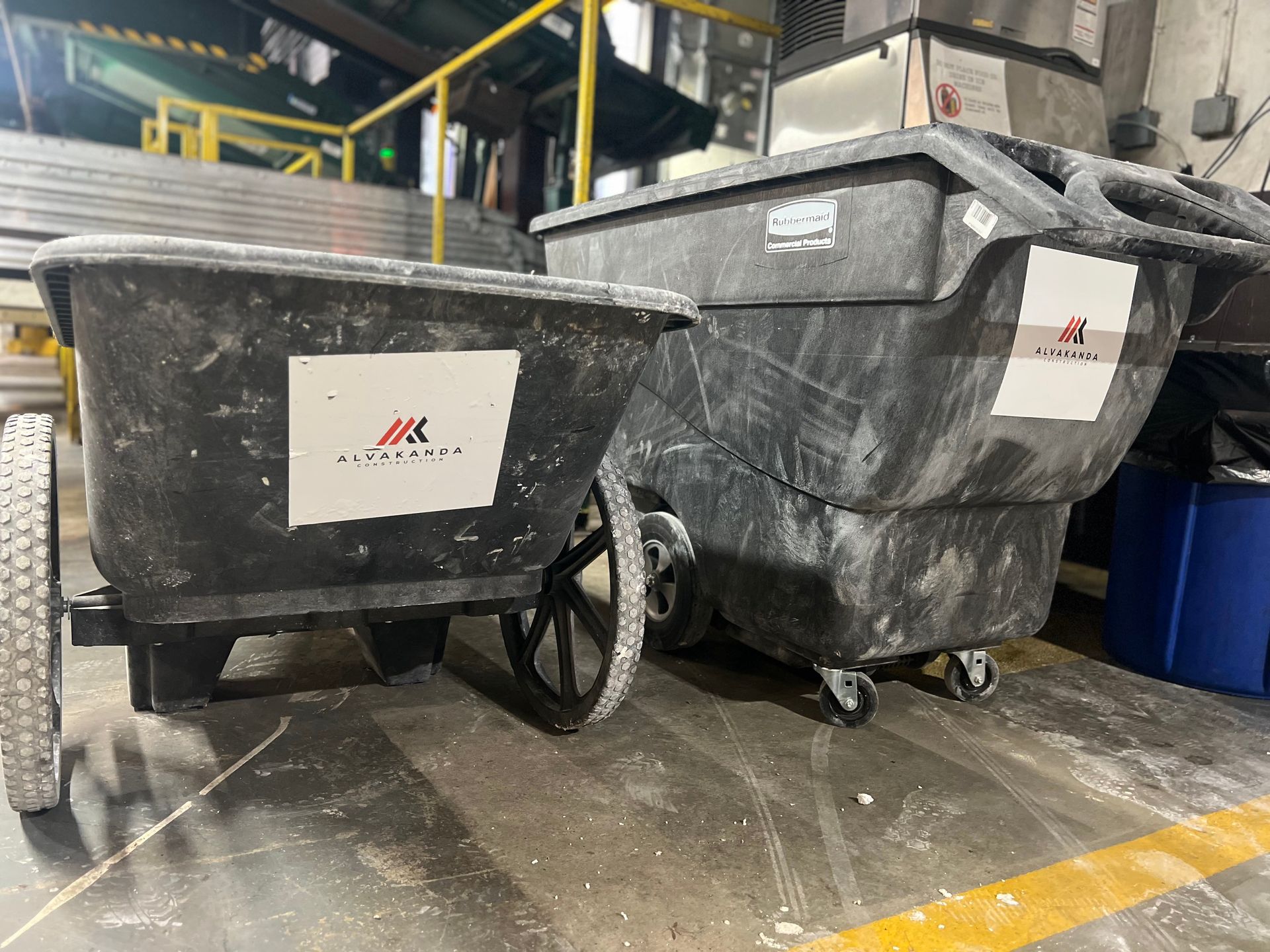 Two wheelbarrows are sitting next to each other in a warehouse.