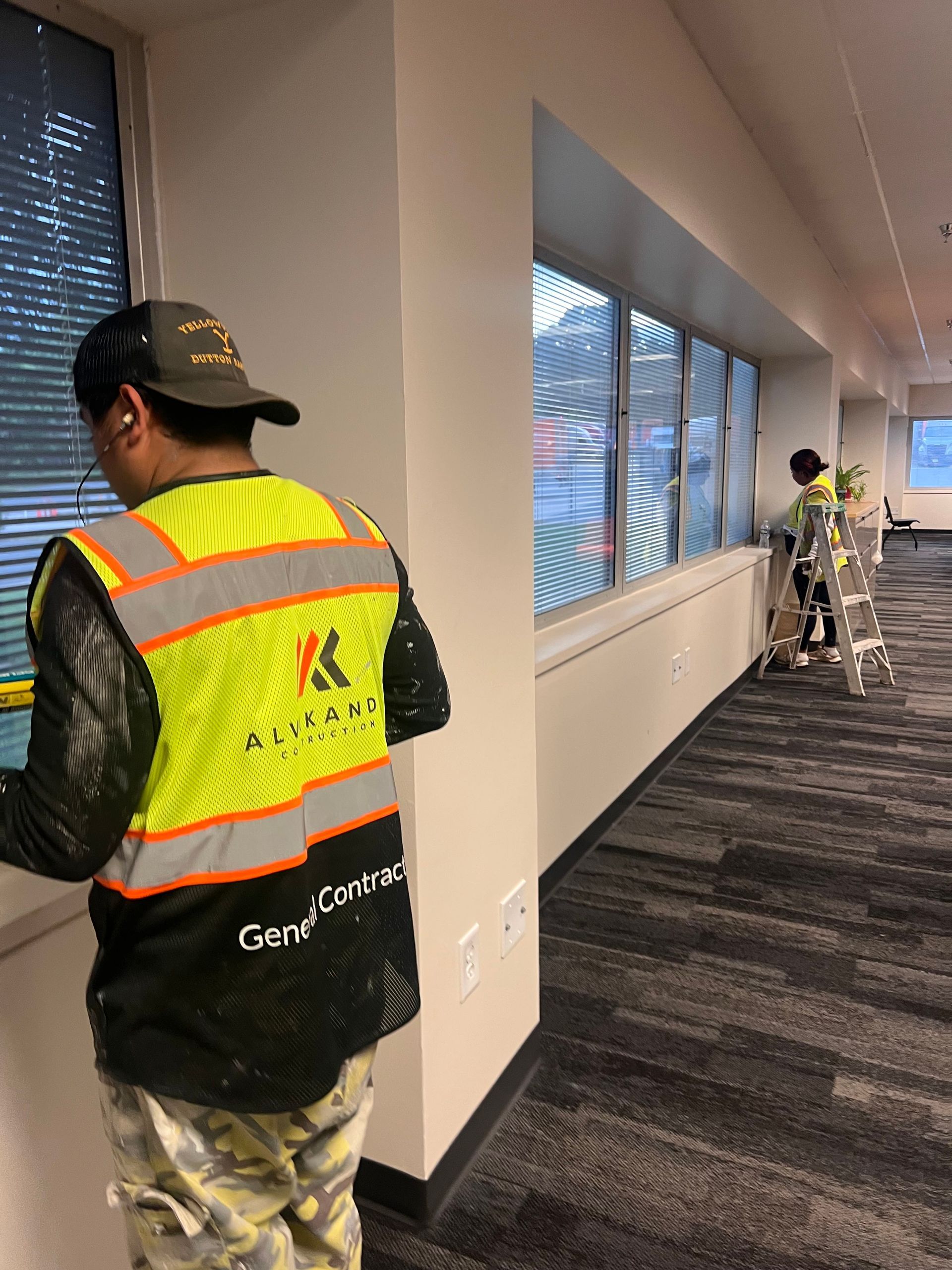 A man wearing a yellow vest with the letter k on it