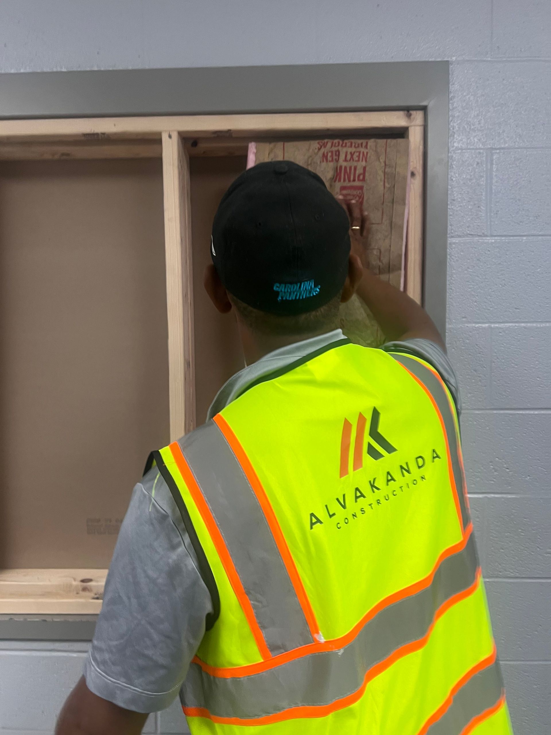 A man wearing a yellow vest that says alvaanda on it