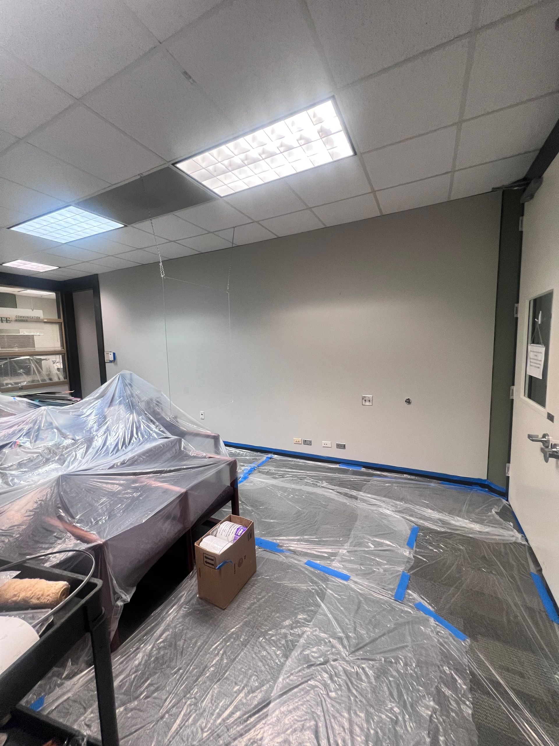 A room is being painted and covered in plastic.