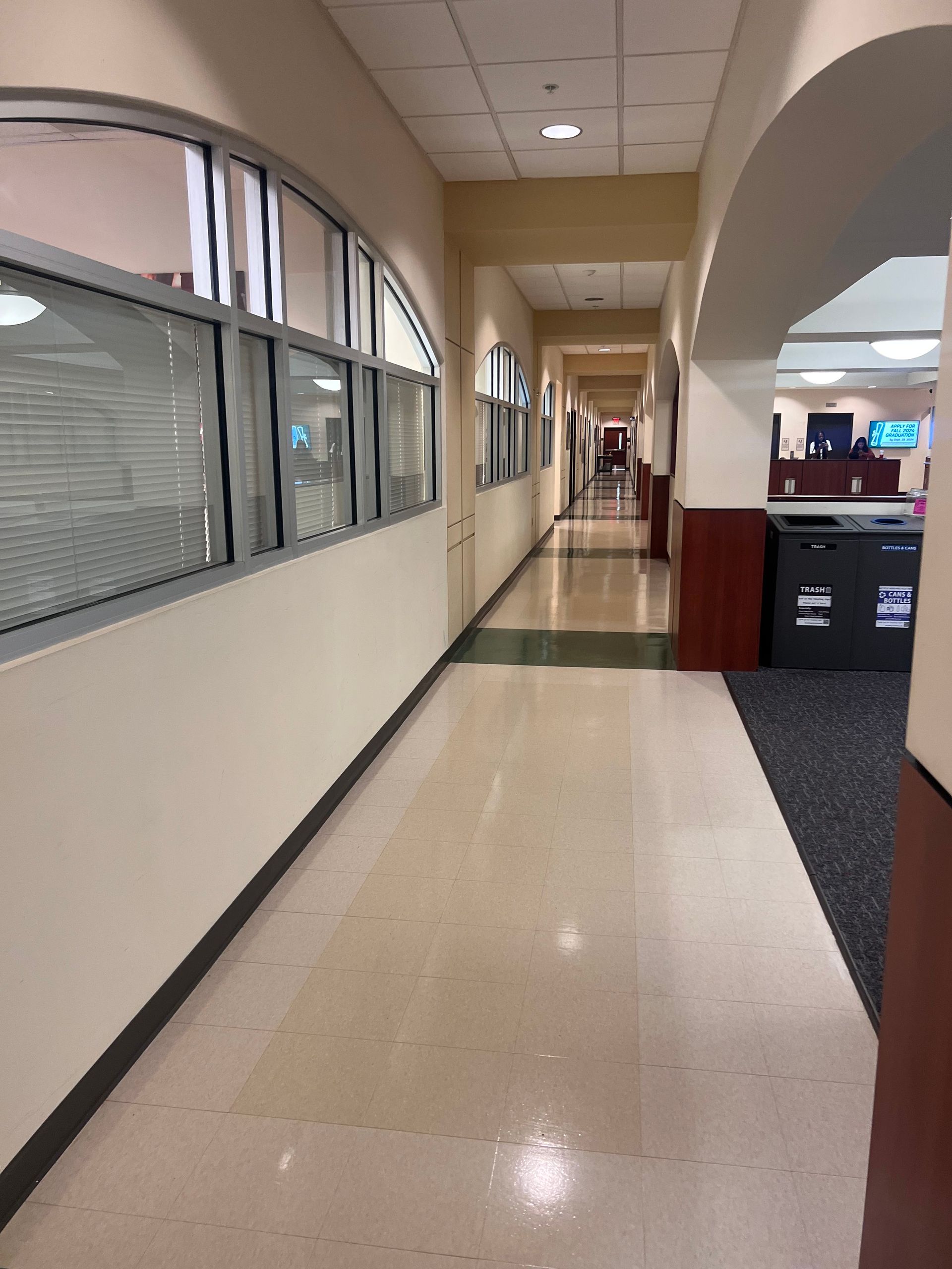 A long hallway in a building with lots of windows