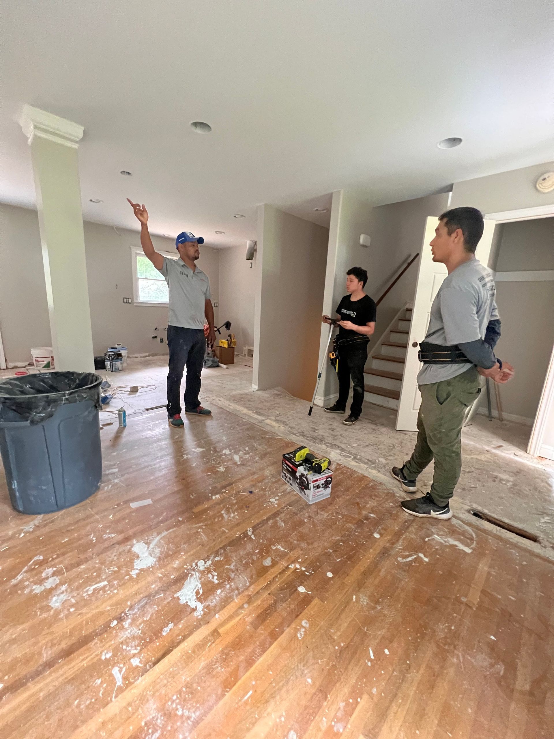 A group of people are standing in an empty room.