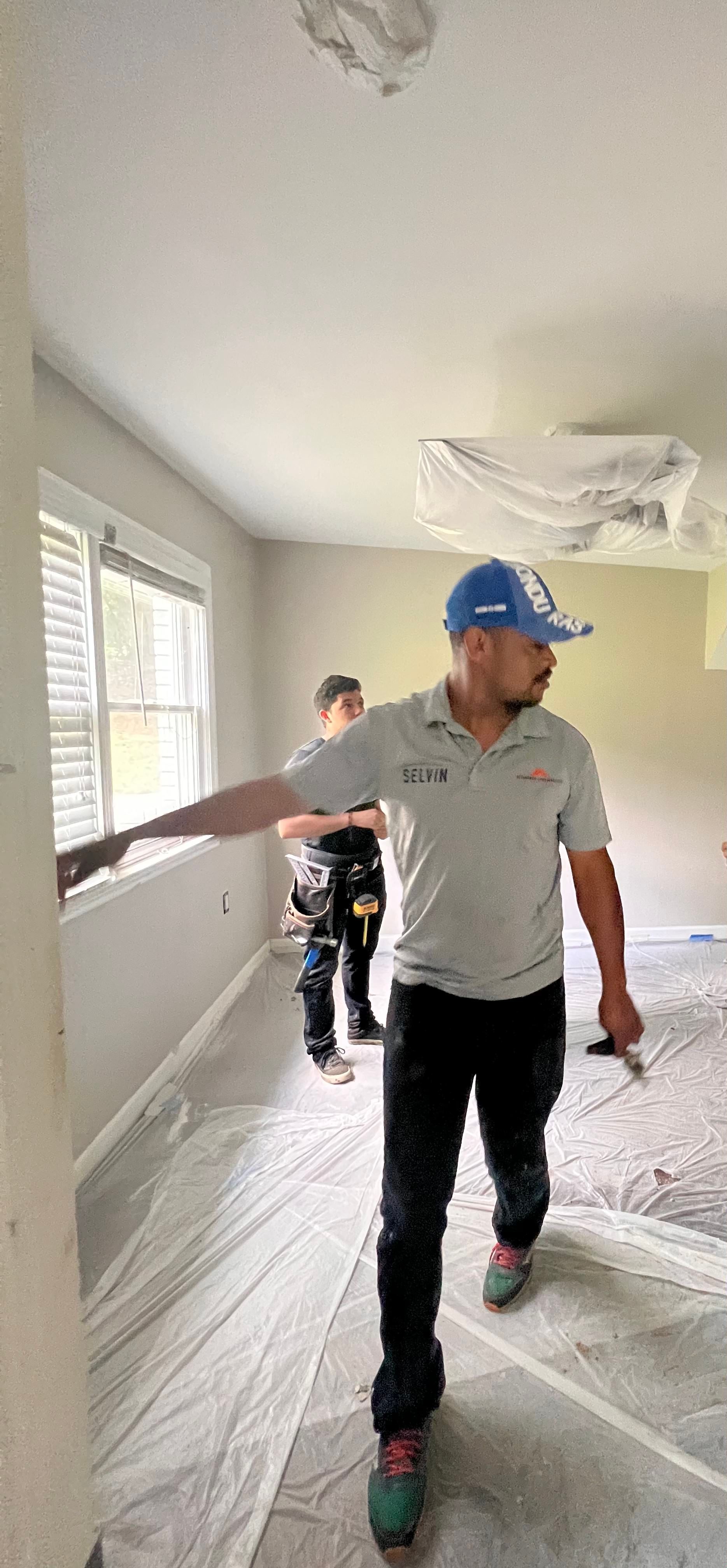 A man is standing in a room with a brush in his hand.