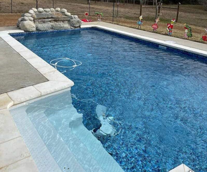 A large swimming pool with a waterfall in the middle of it.