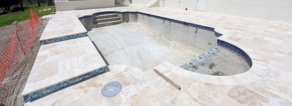 A swimming pool is being built in the backyard of a house.