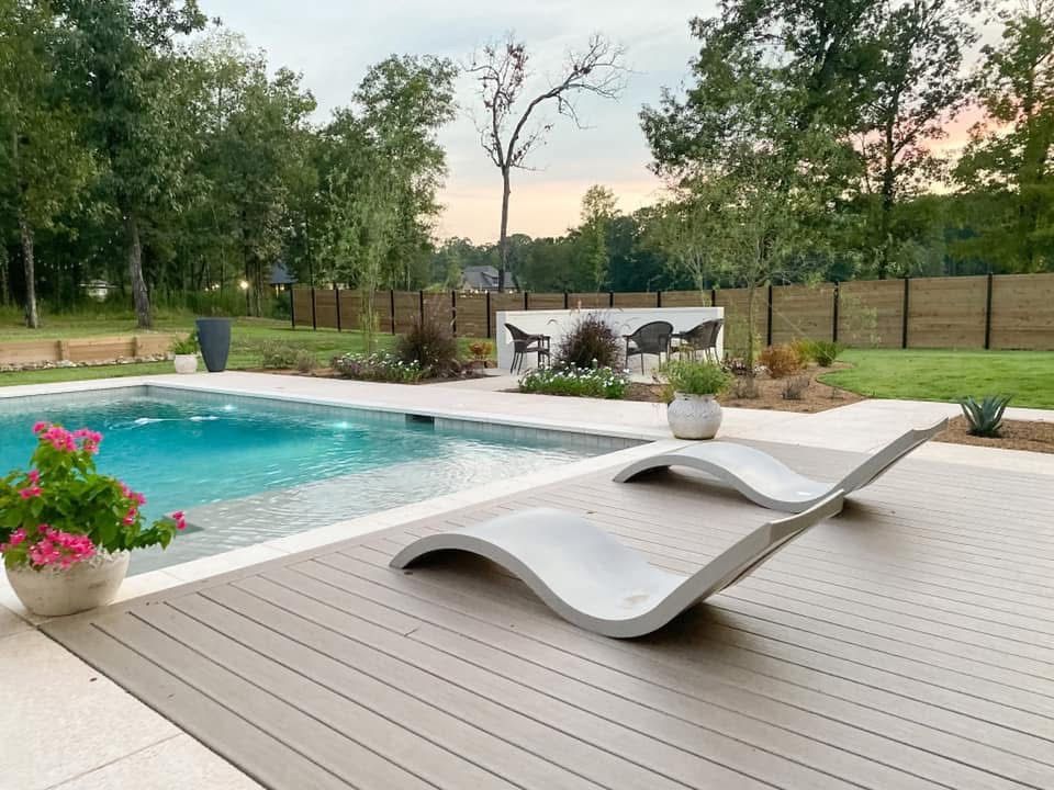 Two lounge chairs are sitting on a wooden deck next to a swimming pool.