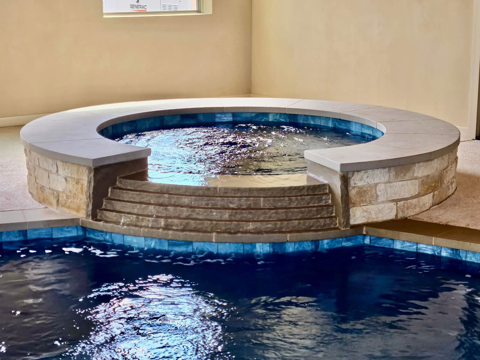 A round hot tub in the middle of a swimming pool.