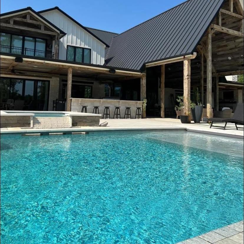 A large house with a swimming pool in front of it.