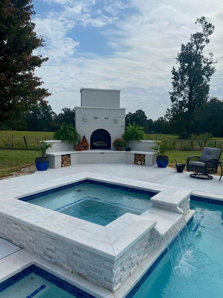 A swimming pool with a fireplace and a hot tub in the backyard.