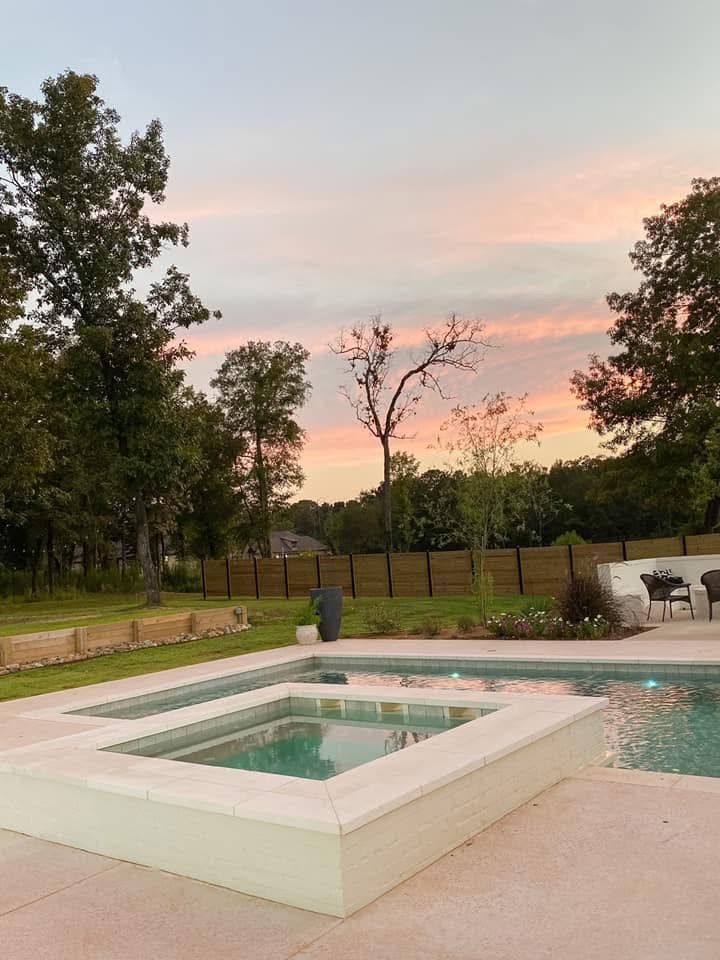 A large swimming pool with a hot tub in the middle of it.
