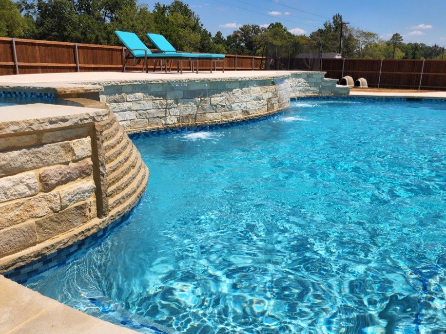 A large swimming pool with a waterfall in the middle of it.