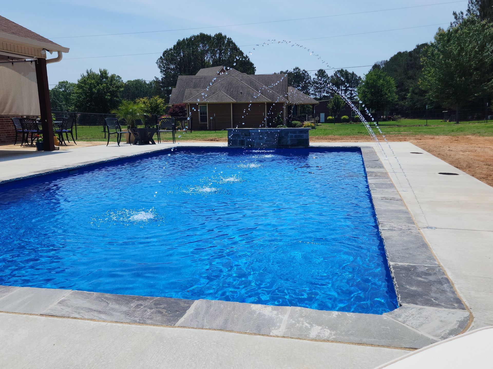 A large swimming pool with a fountain in the middle.