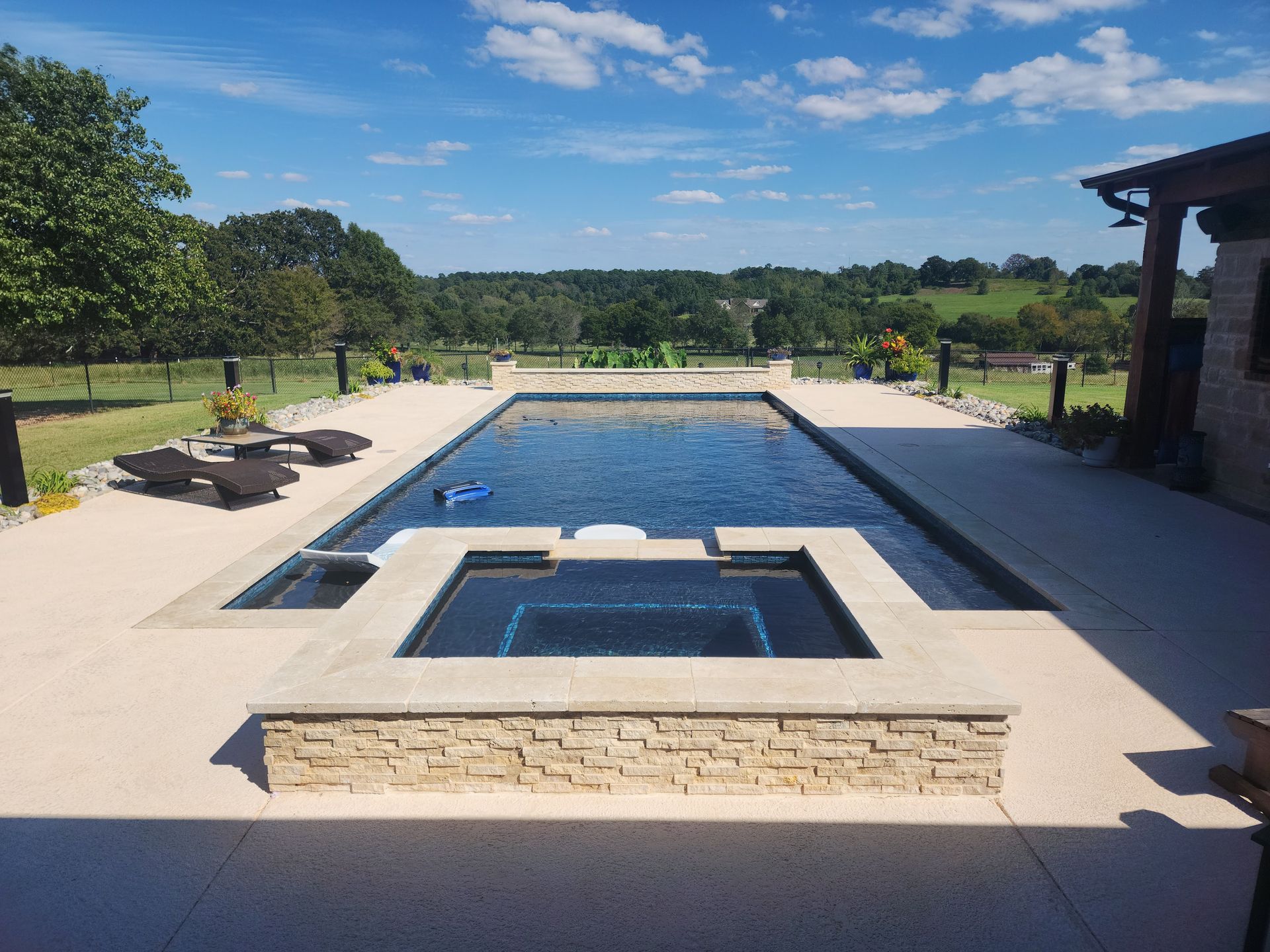 A large swimming pool with a hot tub in the middle of it.