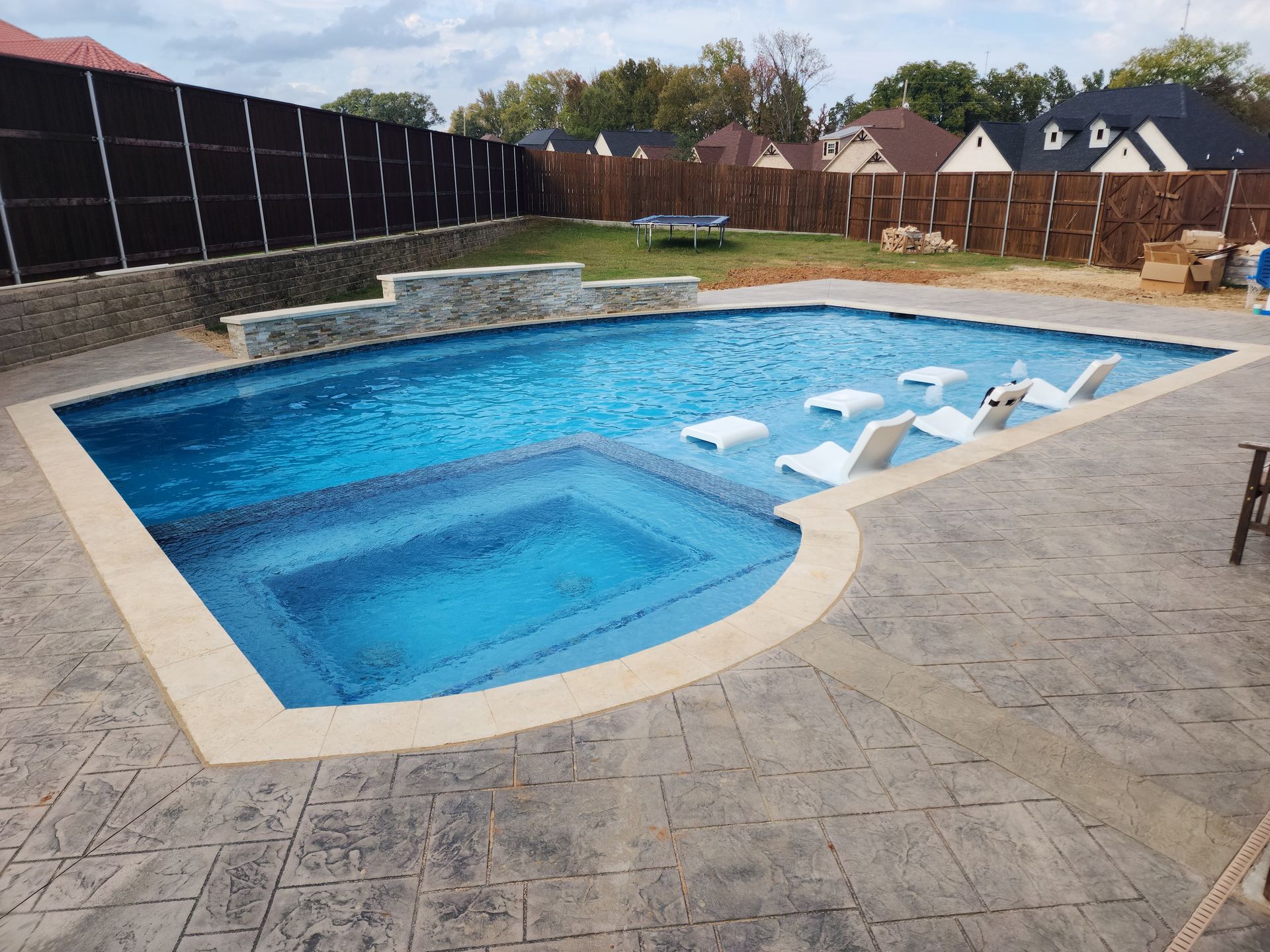 A large swimming pool with a hot tub in the middle.