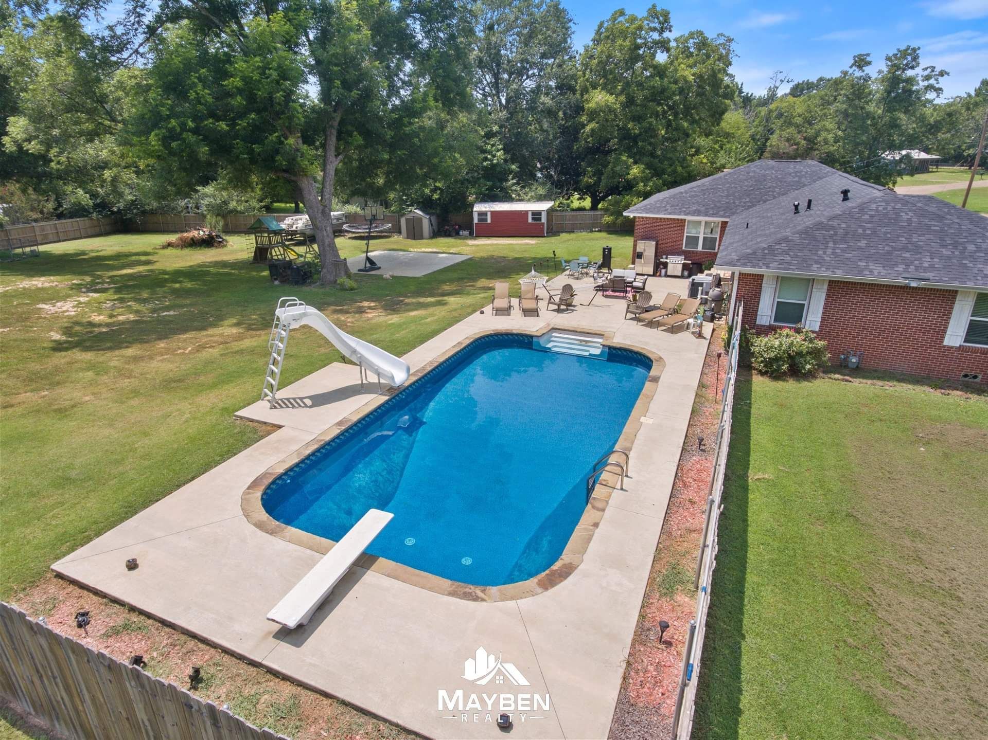 An aerial view of a large swimming pool in the backyard of a house.