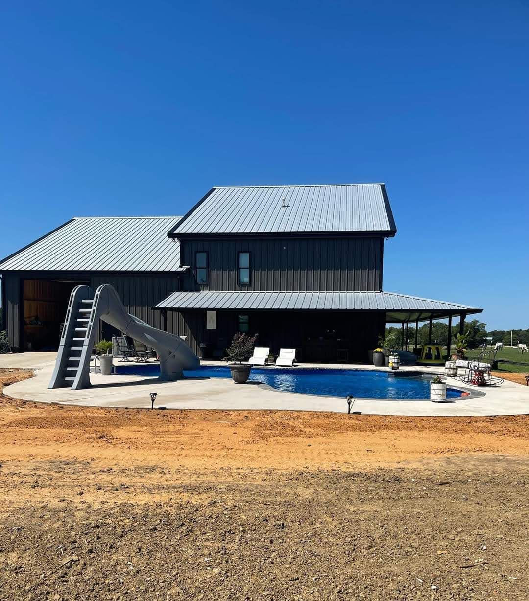 A large house with a pool and a slide in front of it.