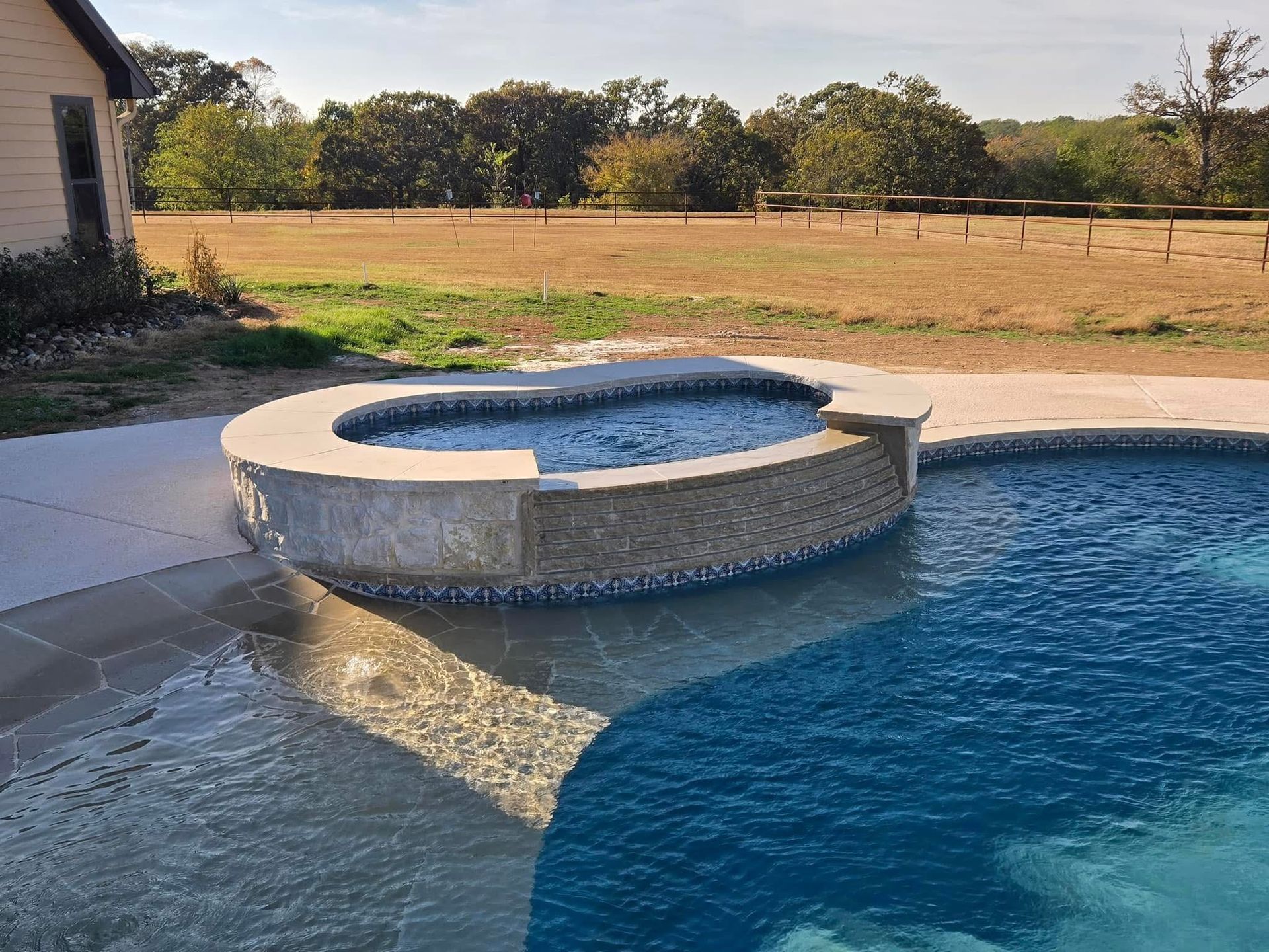 A swimming pool with a hot tub in the middle of it.