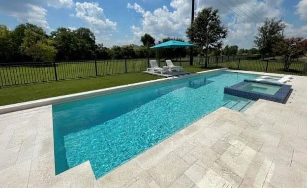 A large swimming pool with a hot tub in the backyard.