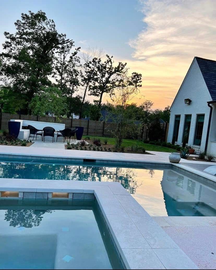 A large swimming pool with a house in the background.