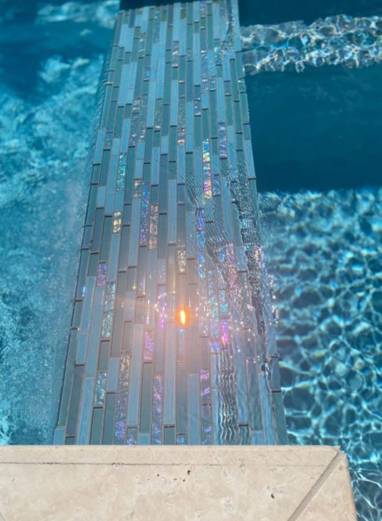 A swimming pool with a tiled walkway leading to it.
