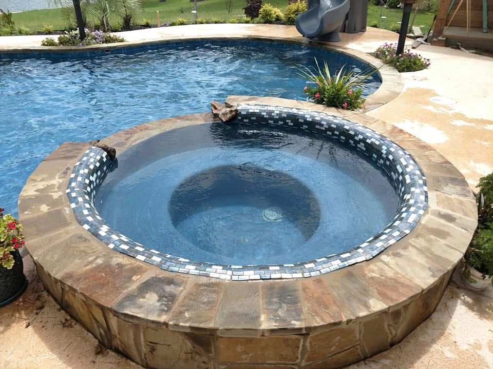 There is a hot tub in the middle of a swimming pool.