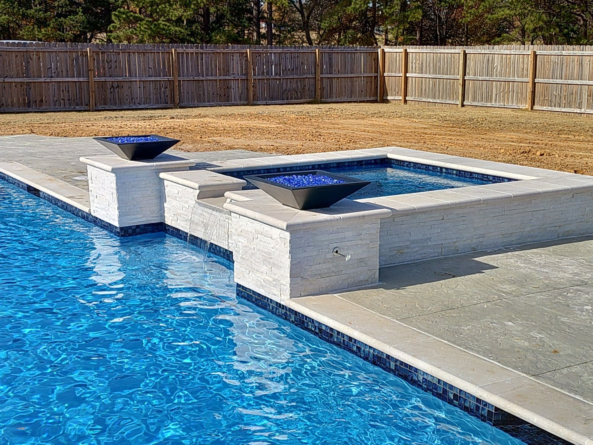 A large swimming pool with a hot tub in the middle.