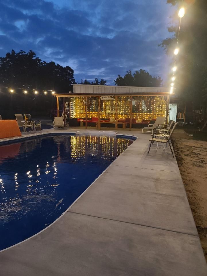 A large swimming pool is lit up at night.