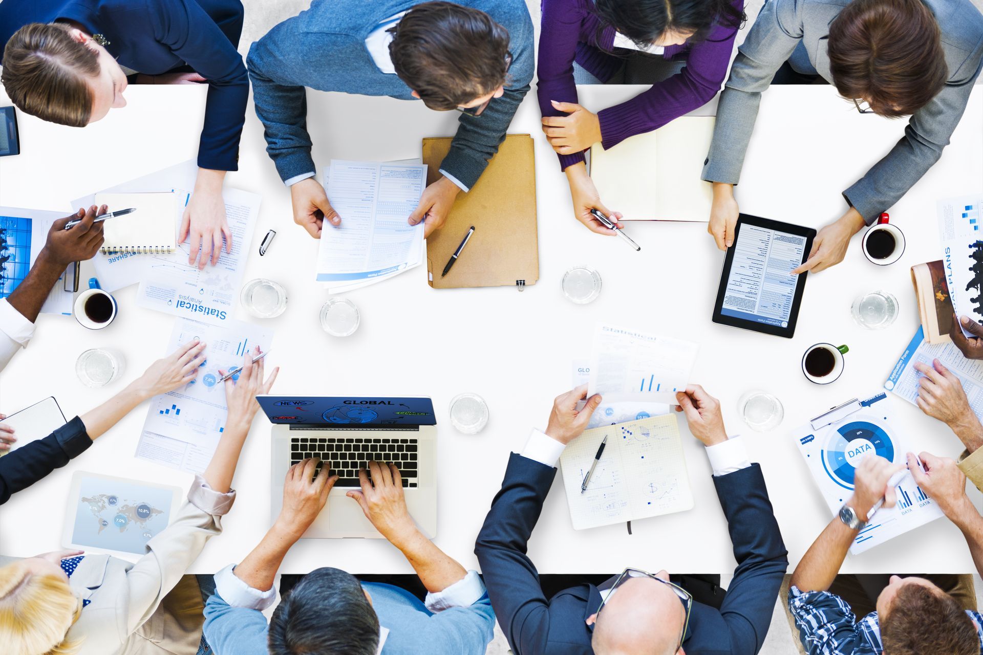 A group of people are sitting around a table having a meeting.