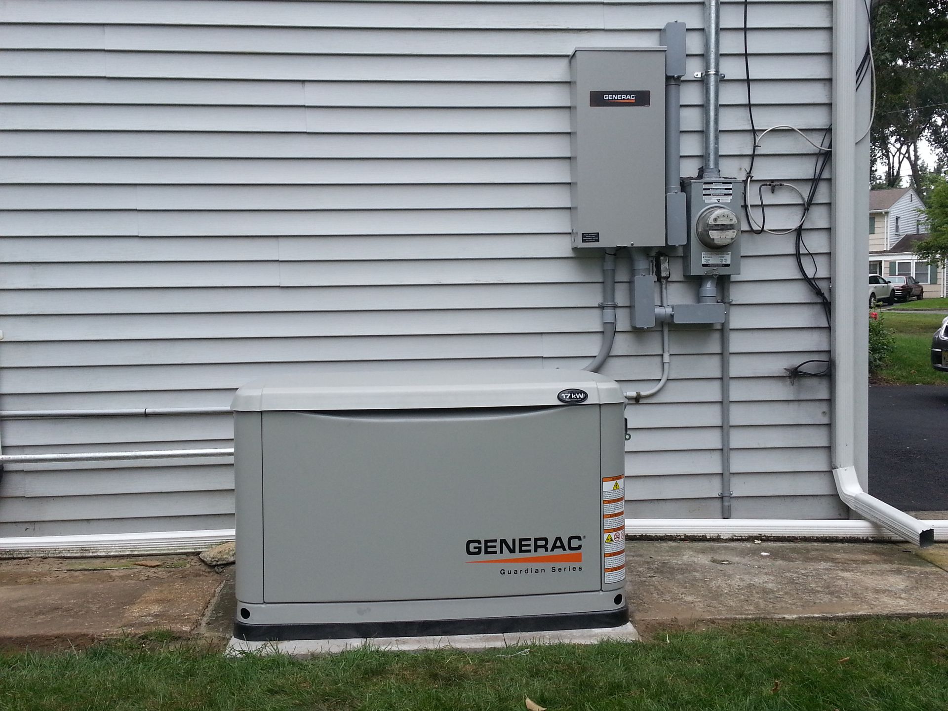 A generator is sitting on the side of a house.