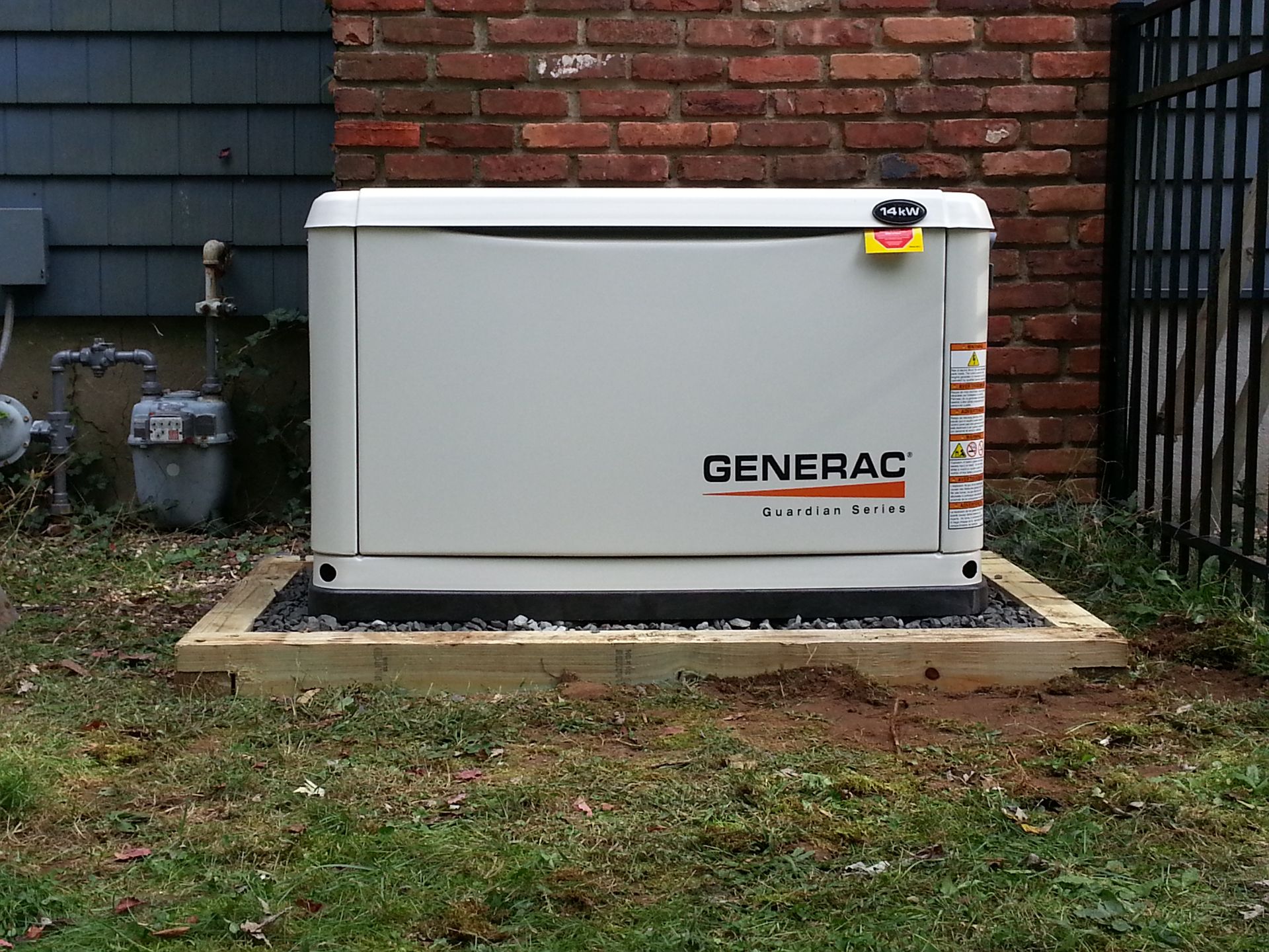 A generac generator is sitting outside of a brick building
