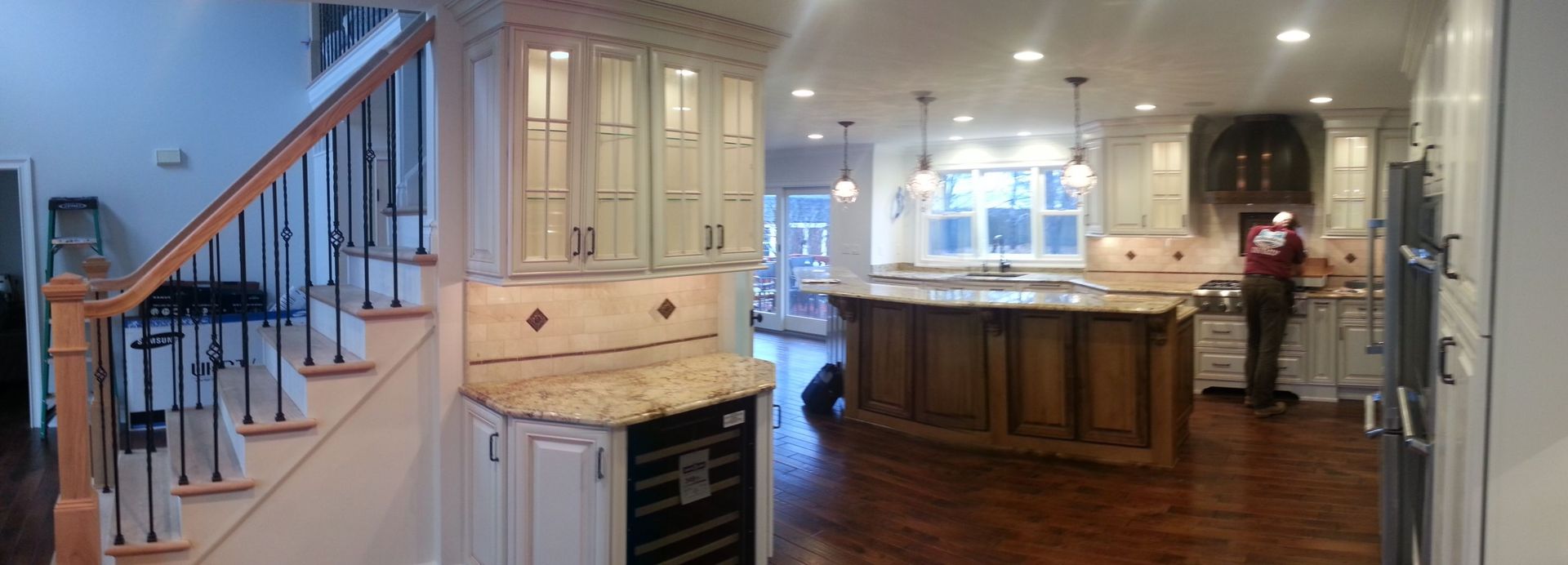 A kitchen with a large island and stairs leading up to it
