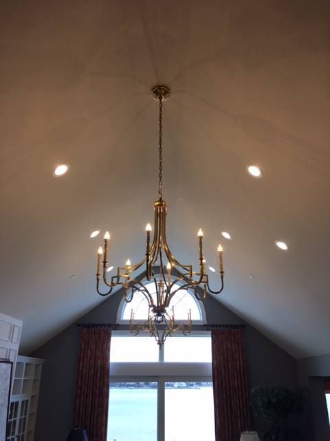 A large chandelier is hanging from the ceiling in a living room.