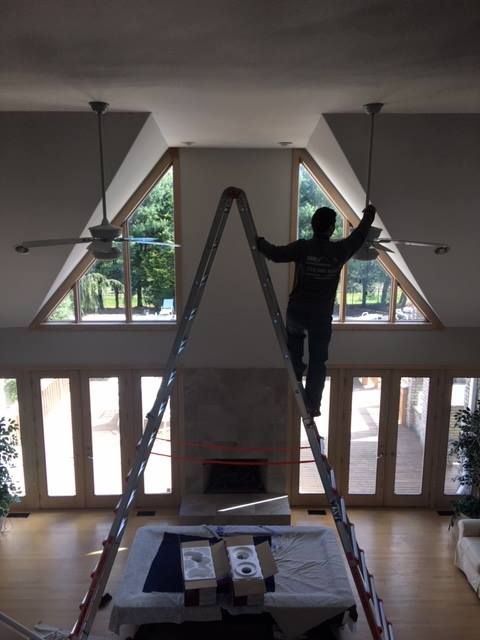 A man standing on a ladder in a living room