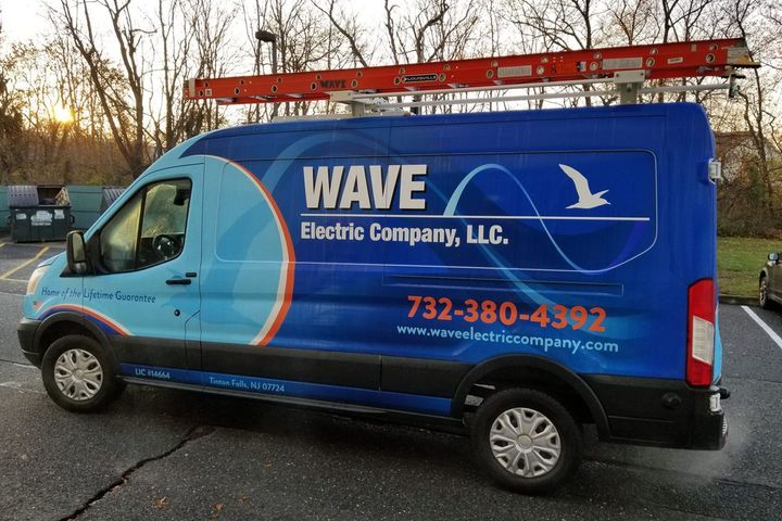 A blue van for wave electric company llc is parked in a parking lot