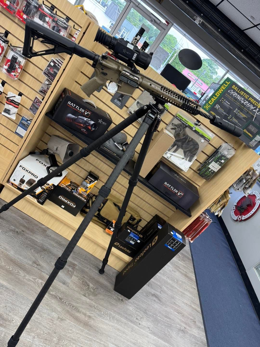 Music store display with guitars, amps, and microphone stands on shelves and a floor stand in front.