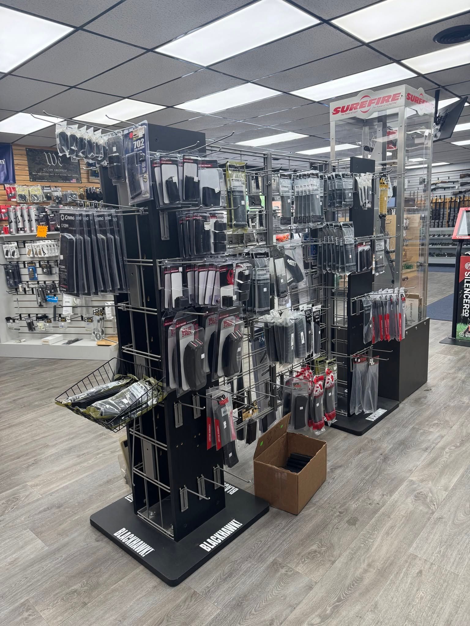 Retail store display of black accessories on hanging racks under bright ceiling lights
