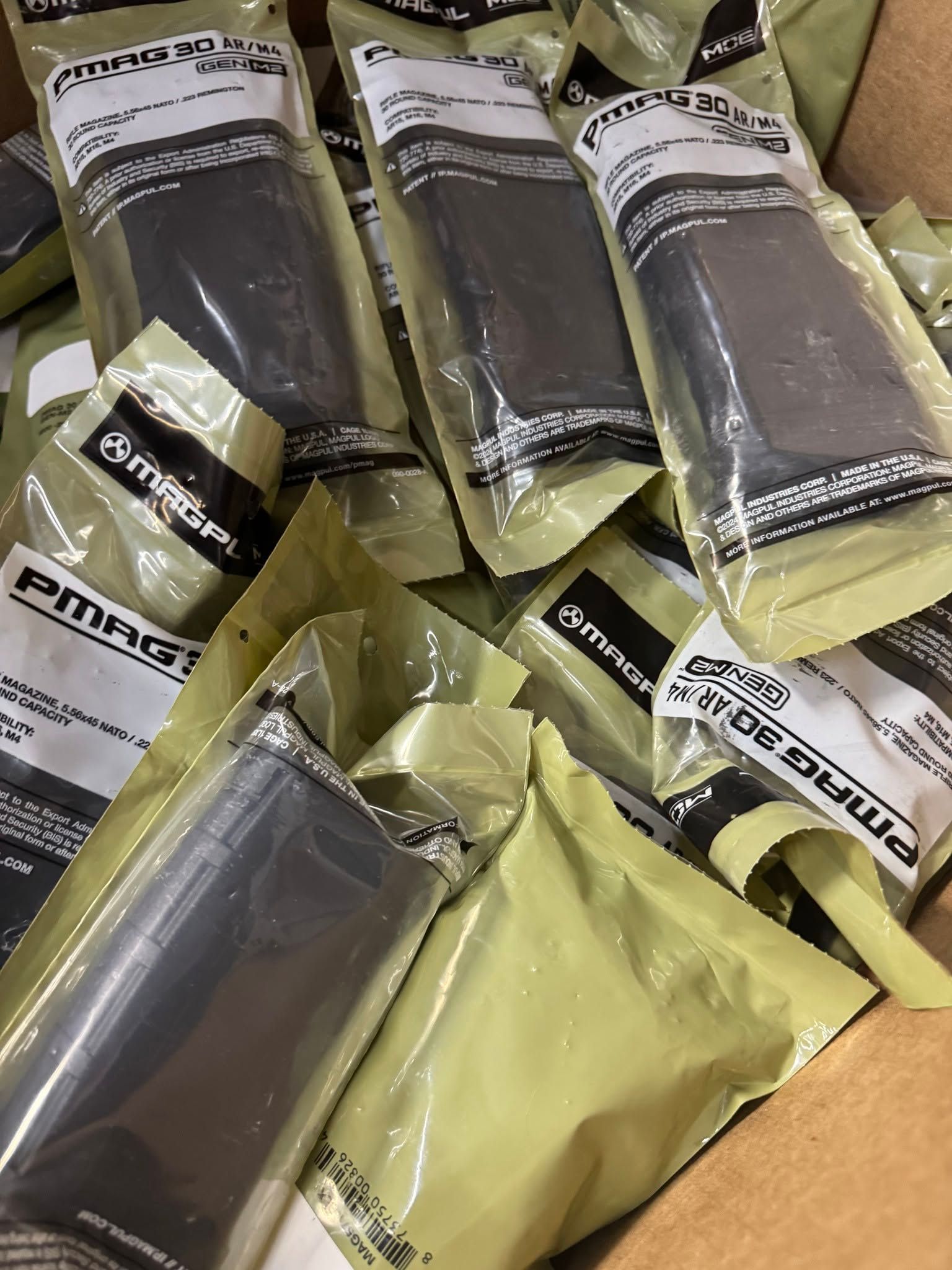 Assorted packaged black sleeves or socks in olive-green plastic wrapping on a shelf