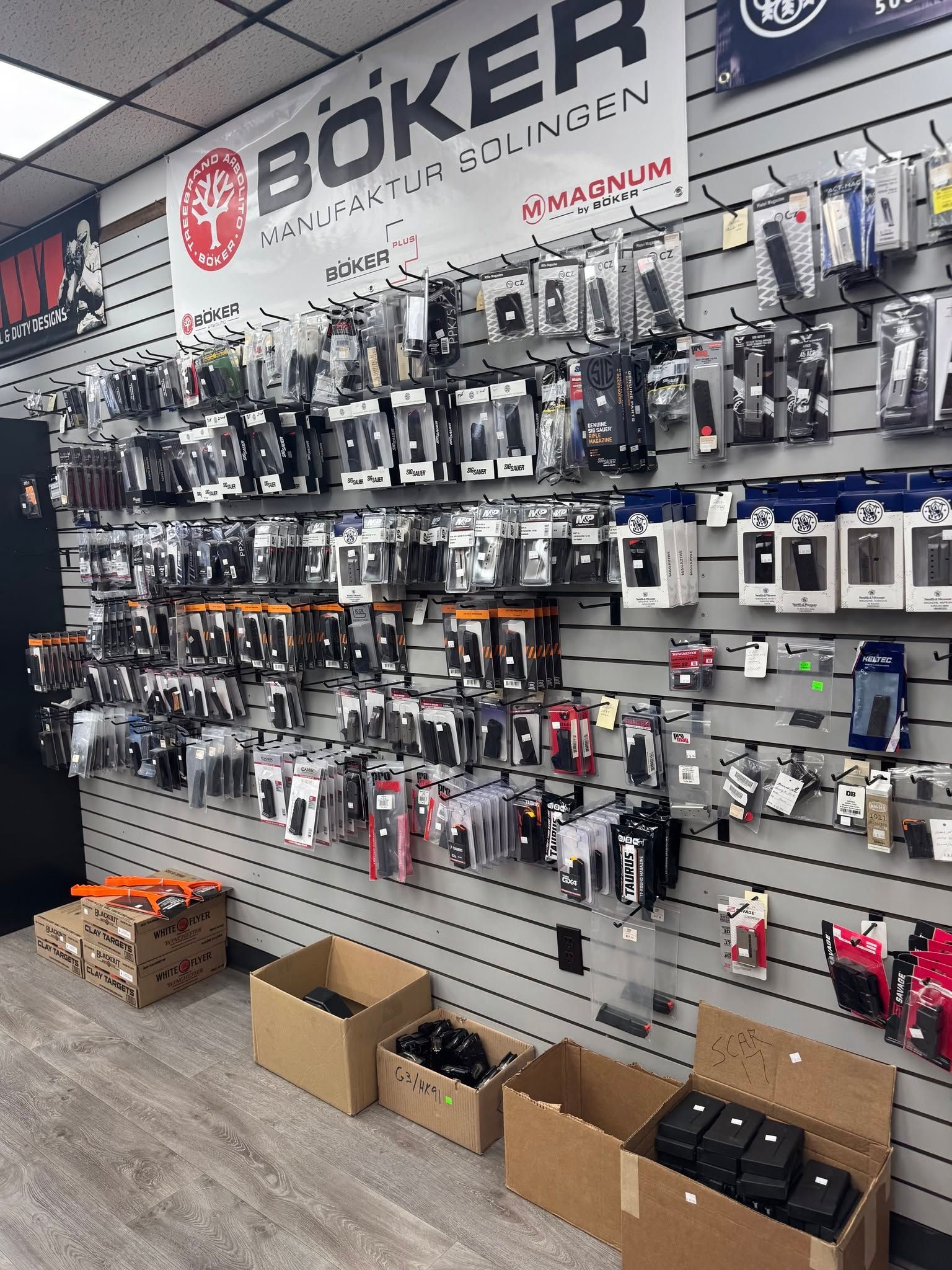 Biker gear wall display with hanging accessories, boxes on the floor, and store signage