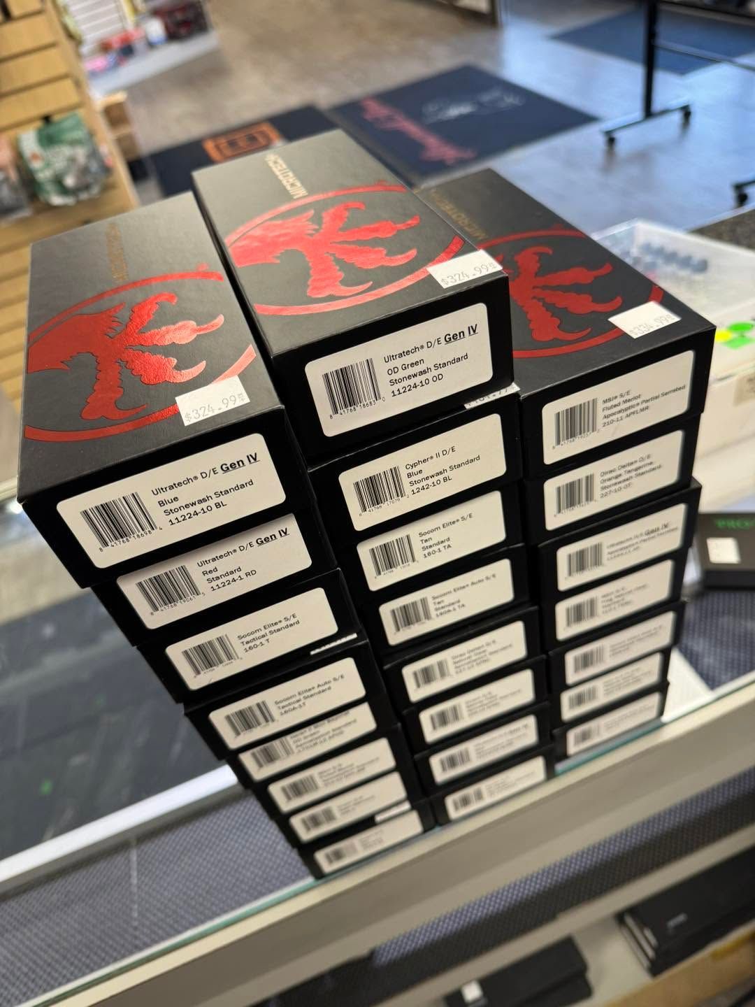 Stack of black retail boxes with red graphics and white labels on a store counter.