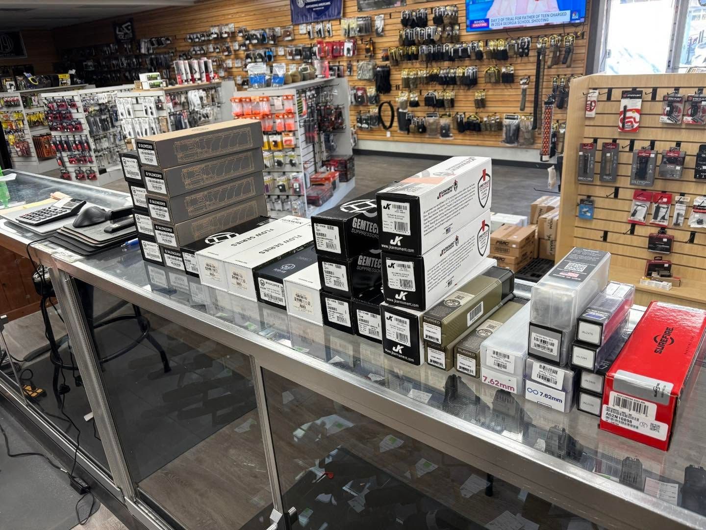 Retail counter with stacks of boxed merchandise and hanging accessories in a store