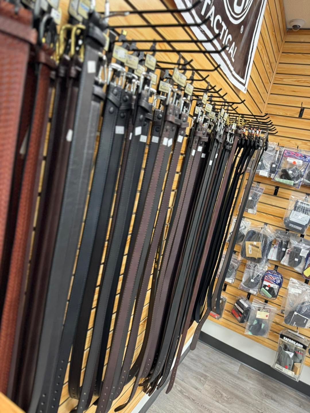 Display of hanging leather belts in a retail store aisle.